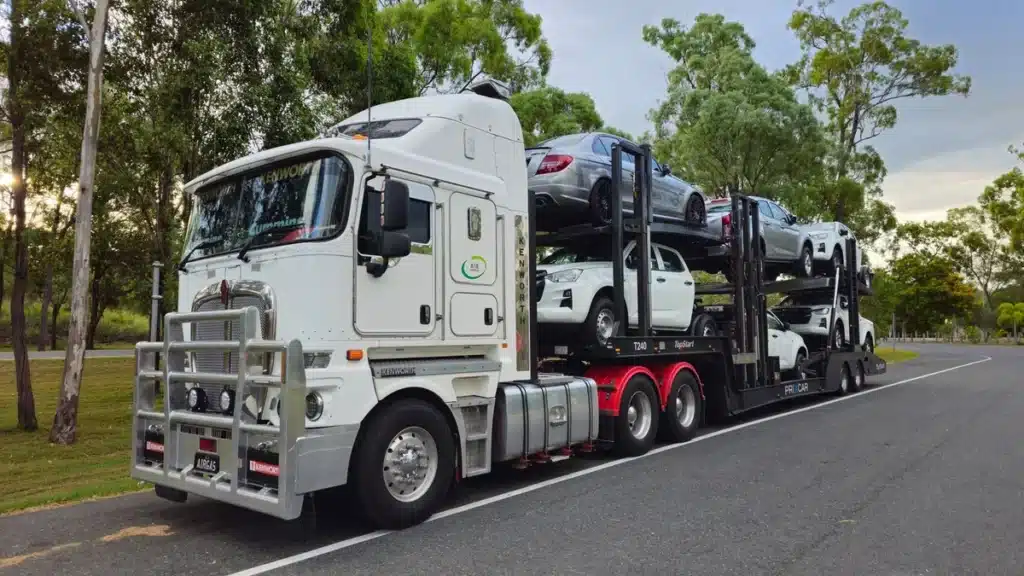 Loaded car carrier transporting vehicles along a highway