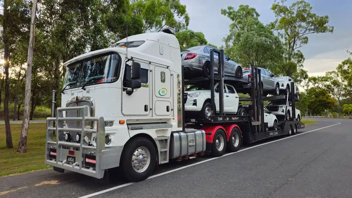 Loaded car carrier transporting vehicles along a highway