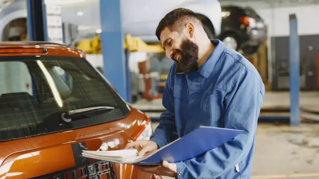 Technician completing a vehicle inspection checklist before transport